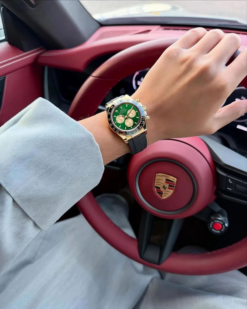 Rolex Cosmograph Daytona in 18k yellow gold with a green dial and a black Oysterflex (rubber) bracelet.
