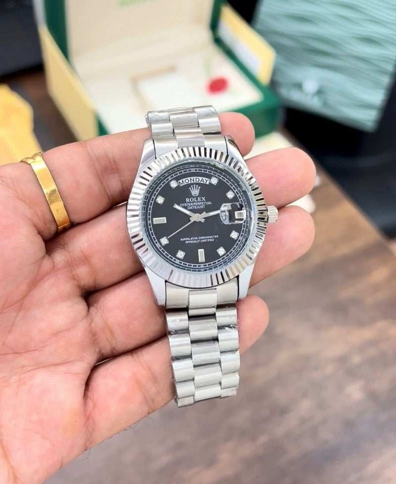 Rolex Day-Date watch with a black dial and a fluted bezel on a President-style bracelet.