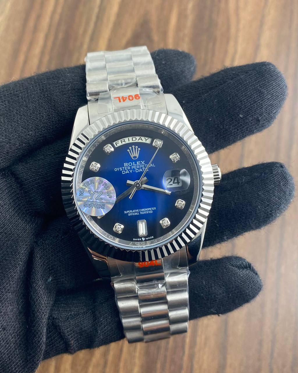 Rolex Day-Date watch with a blue dial, diamond hour markers, and a stainless steel President bracelet.