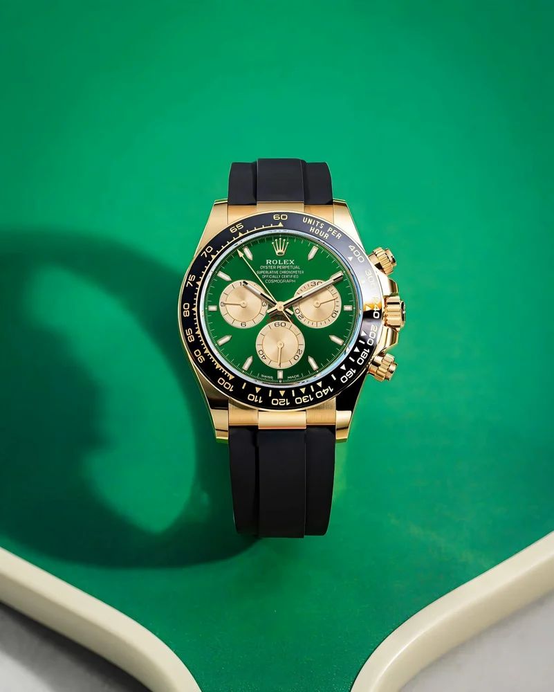 Rolex Cosmograph Daytona in 18k yellow gold with a green dial and a black Oysterflex (rubber) bracelet.