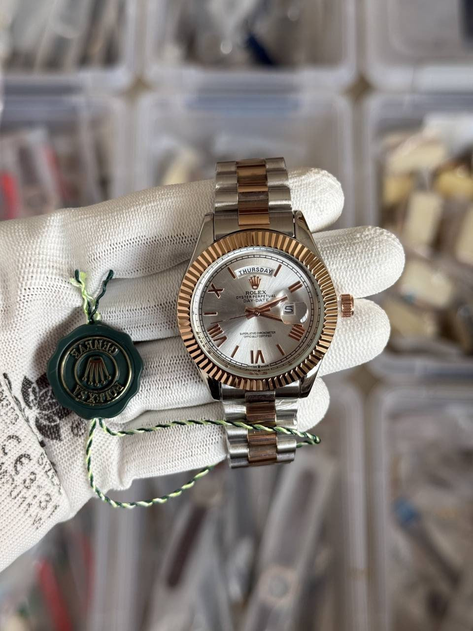 Rolex Oyster Perpetual Day-Date watch featuring a white dial, a fluted bezel, and a two-tone metal President bracelet.